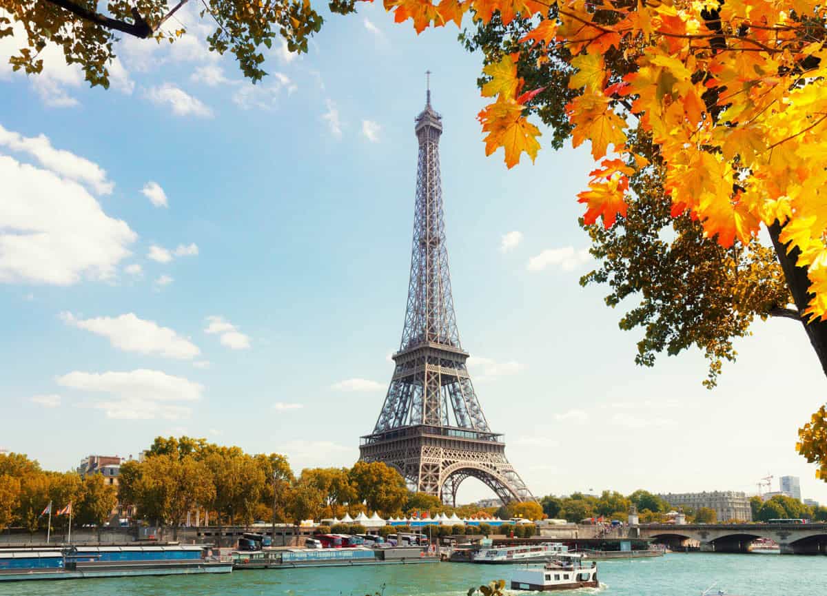 Eiffel Tower above the Seine framed by orange autumn foliage — Eiffel Tower, Paris, France.