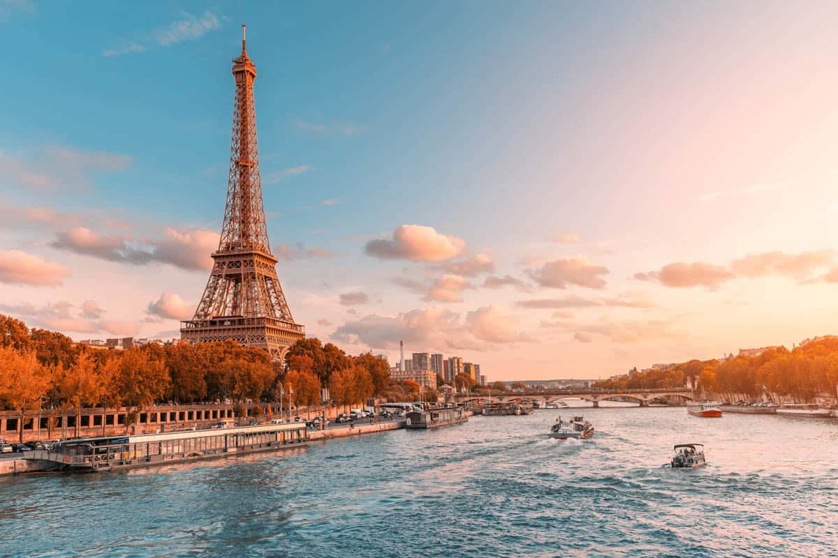 Eiffel Tower and a sightseeing boat on the Seine at sunset — Eiffel Tower, Paris, France.