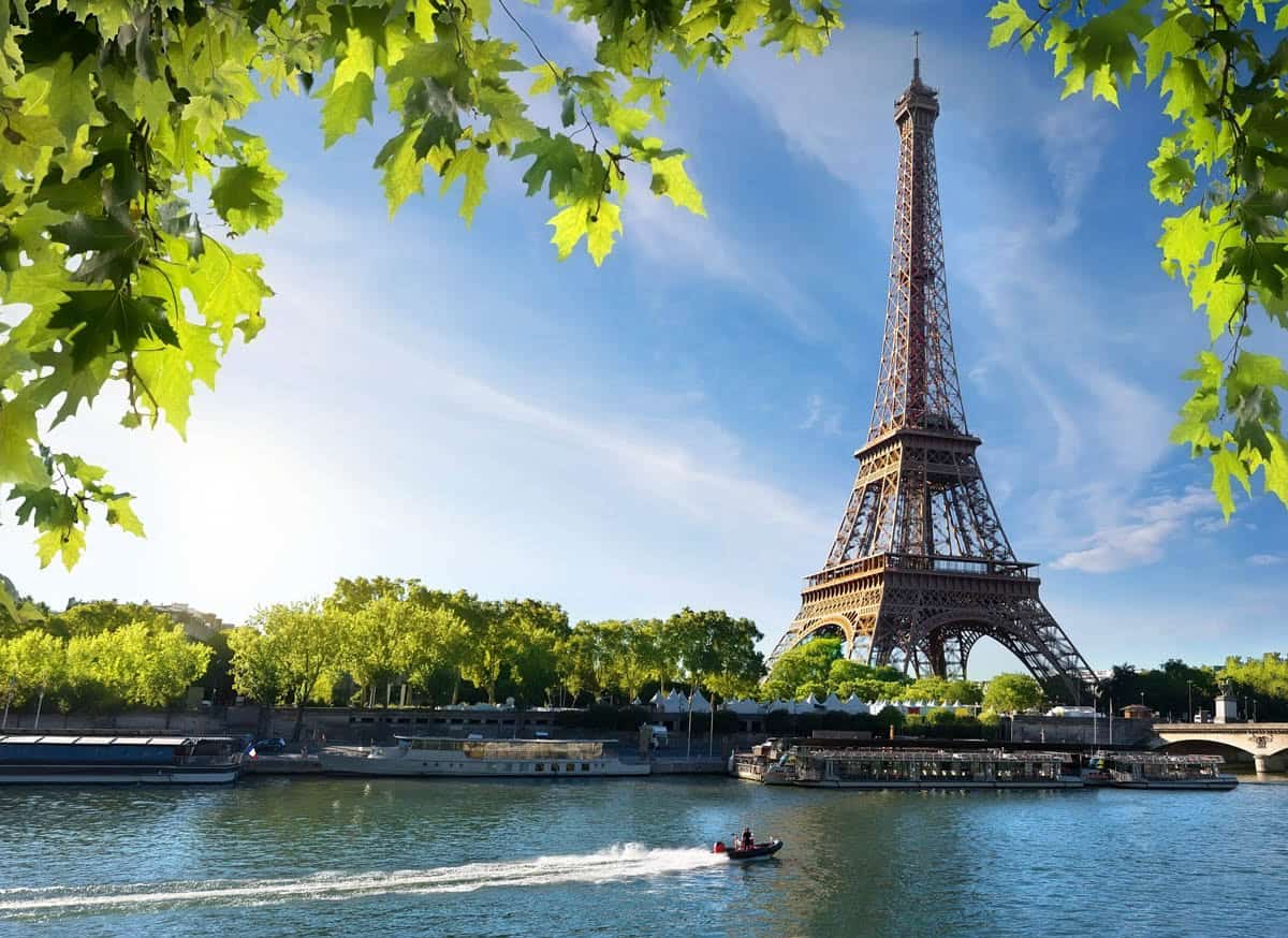 Eiffel Tower across the Seine beneath bright green foliage — Eiffel Tower, Paris, France.