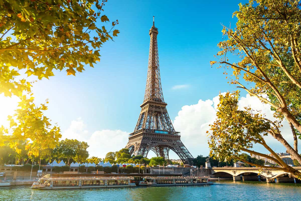 Eiffel Tower across the Seine framed by autumn leaves — Eiffel Tower, Paris, France.