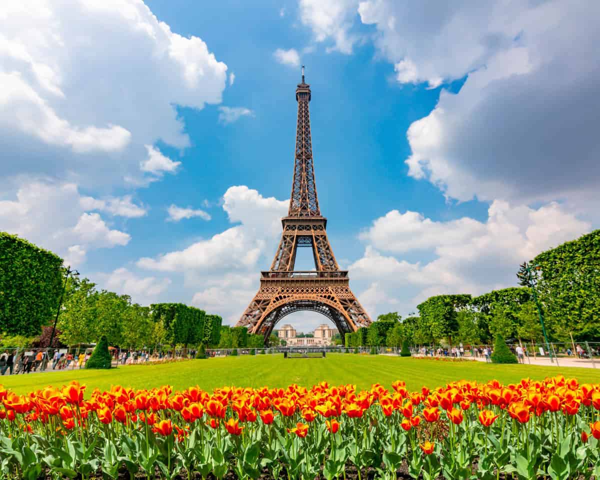 Eiffel Tower beyond bright flowerbeds and trimmed lawns — Eiffel Tower, Paris, France.