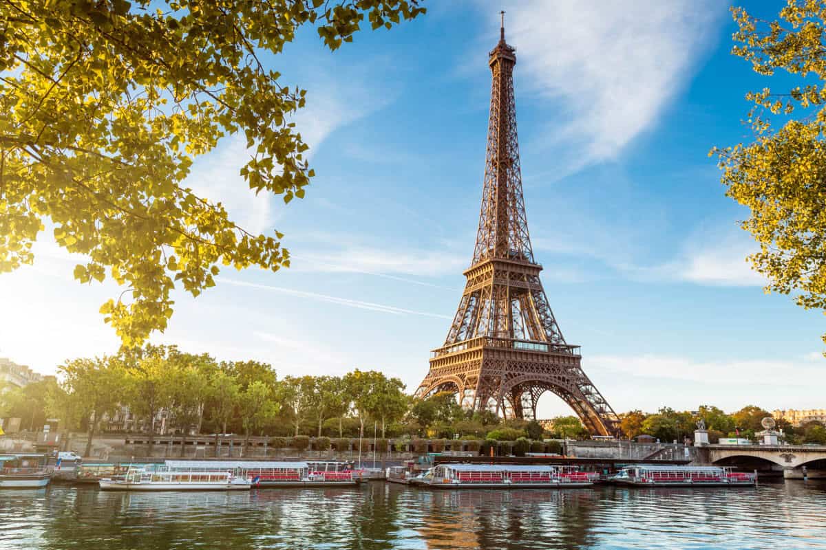 Eiffel Tower reflected in the Seine beneath golden foliage — Eiffel Tower, Paris, France.