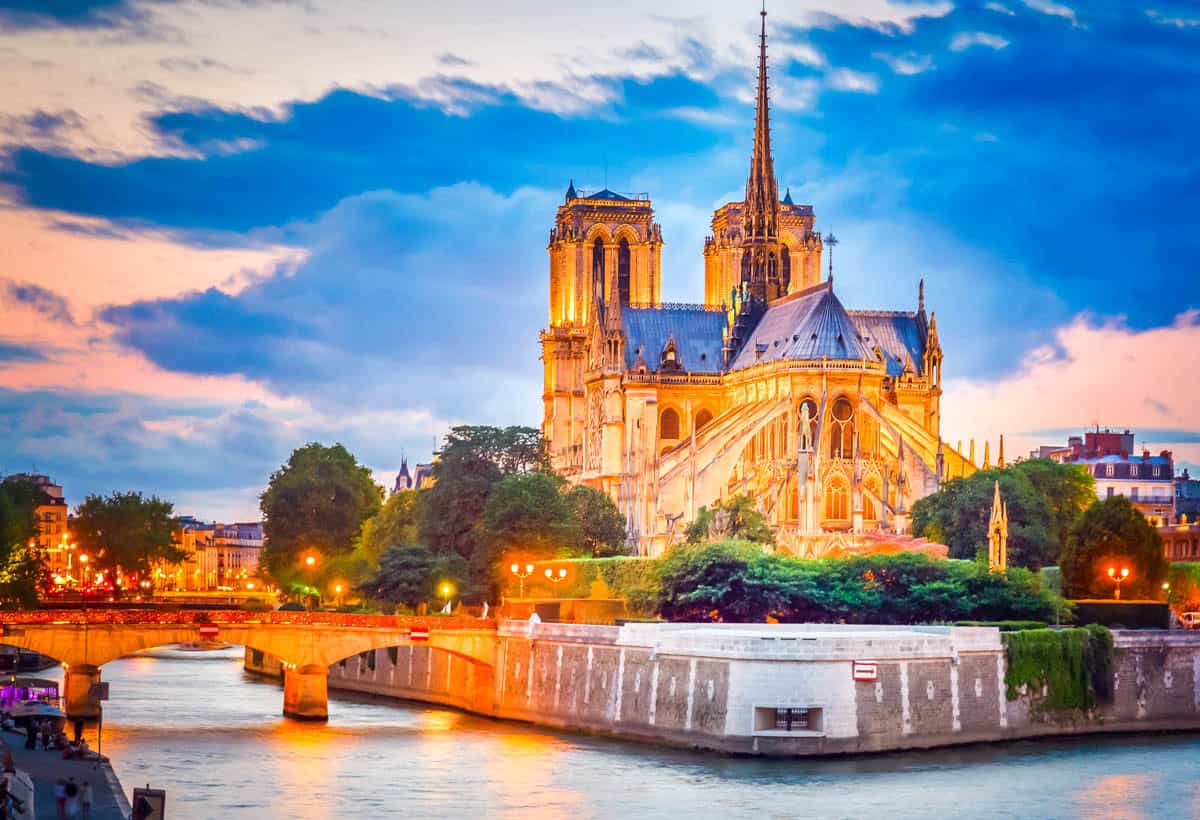 Notre-Dame Cathedral in Paris, France, with Notre-Dame apse, Seine embankment, and fountain at sunset.