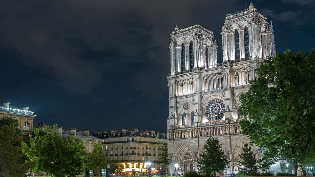 Notre-Dame Cathedral in Paris, France, with Notre-Dame west towers illuminated against the night sky.