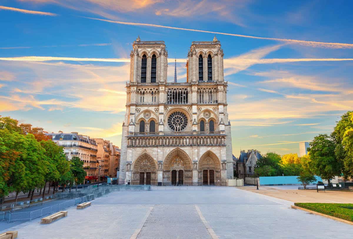 Notre-Dame west façade across an open daylight plaza alongside cathedral details at Notre-Dame Cathedral in Paris, France.