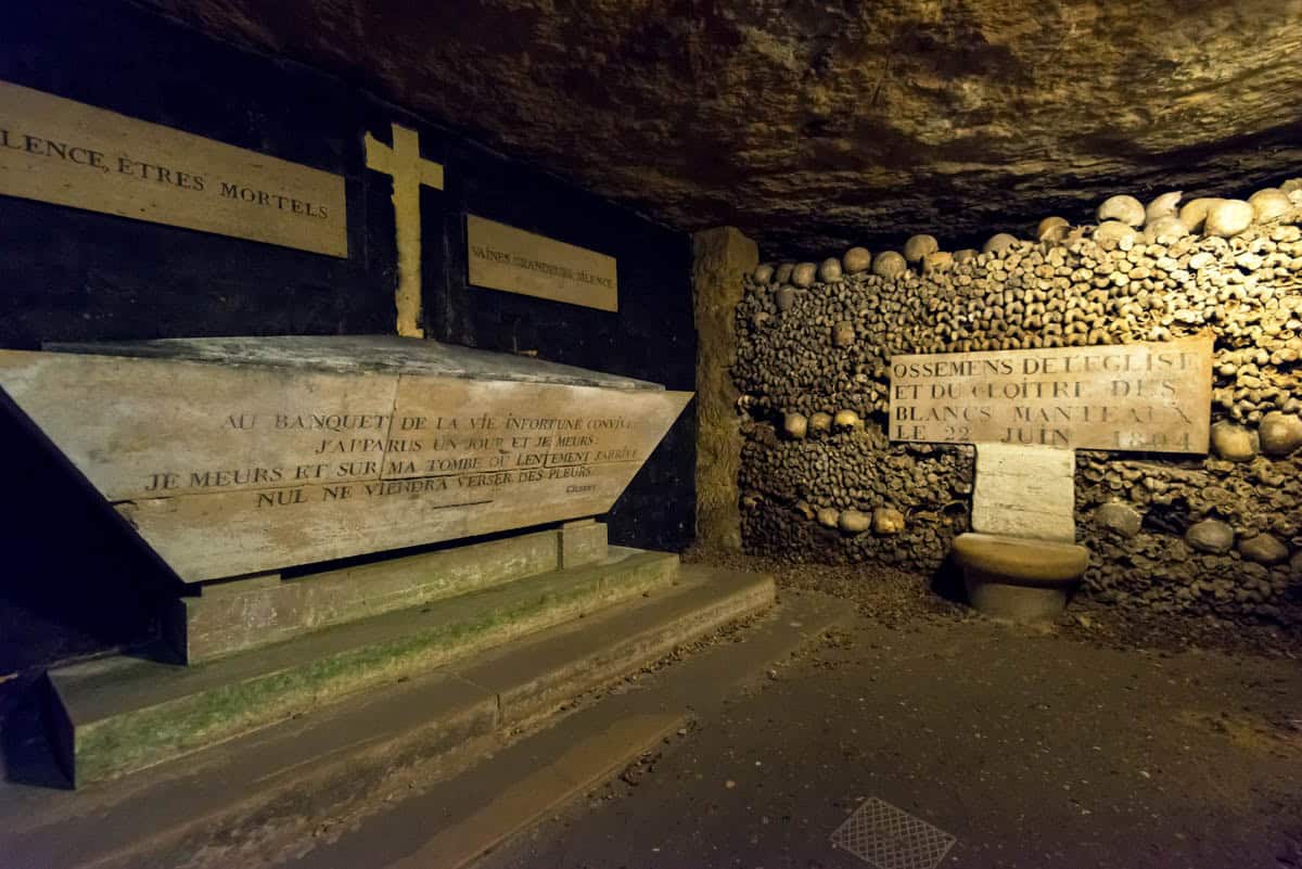 Tomb-like memorial structure flanked by crosses and bone walls — Paris Catacombs, Paris, France.