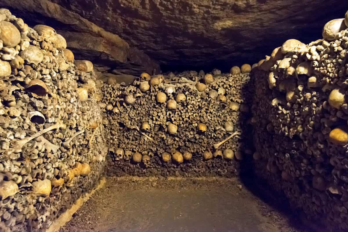 Paris Catacombs in Paris, France, with compact underground chamber enclosed by patterned bone walls.