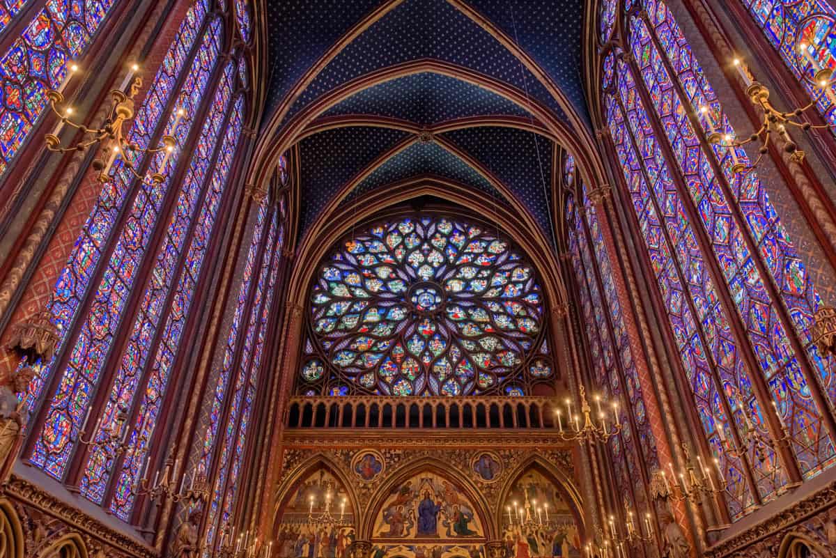 Soaring stained-glass walls and ribbed vault above the upper chapel framed by stained glass and gothic chapel at Sainte-Chapelle in Paris, France.