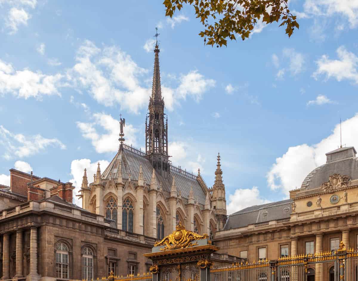 Sainte-Chapelle in Paris, France, featuring blue star-patterned vault and radiating ribs above stained glass beside stained glass features.