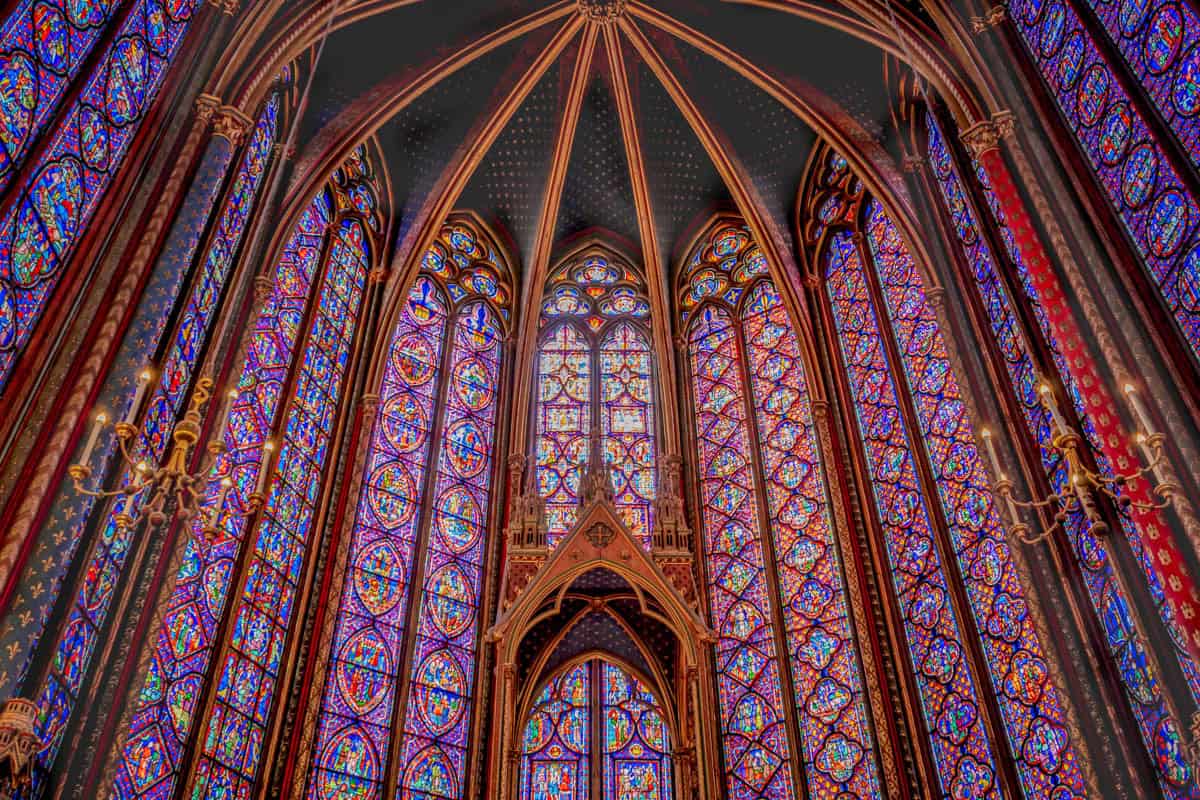 Sainte-Chapelle in Paris, France, featuring central upper-chapel aisle leading toward the altar and stained glass beside stained glass features.