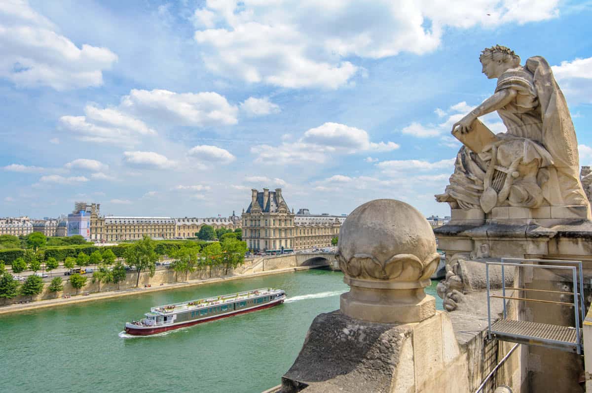 Seine River's river setting in Paris, France contains stone bridge sculpture overlooking the Seine and central Paris riverbanks.