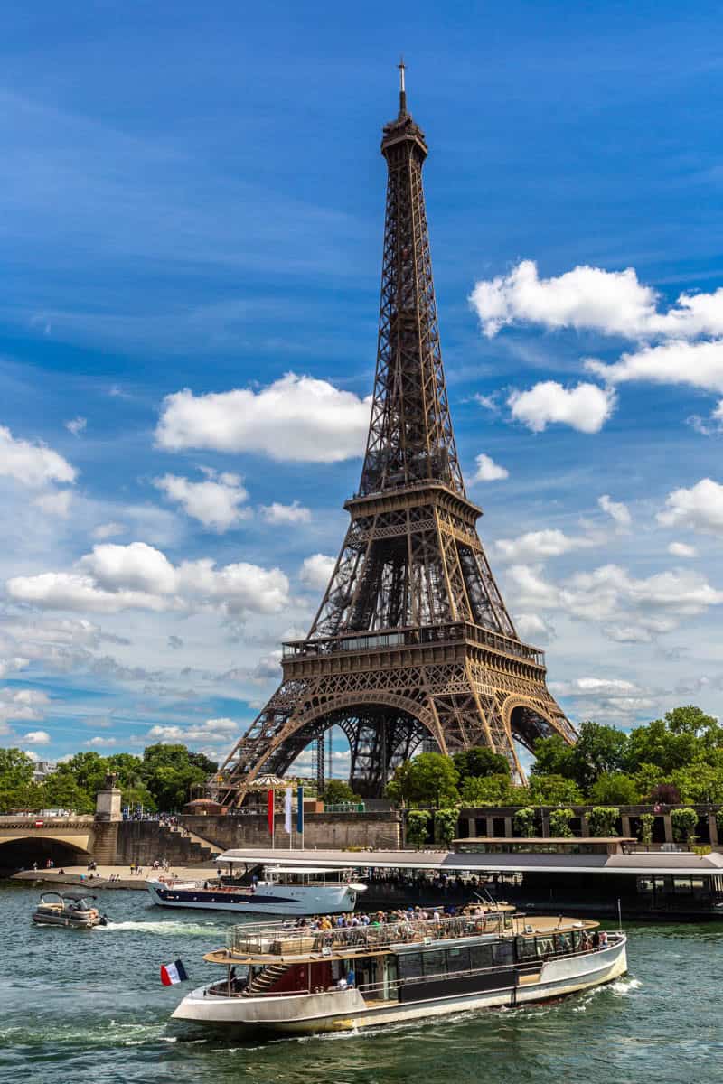 Seine River in Paris, France pairs Eiffel Tower rising behind a passenger boat on the Seine with river details.